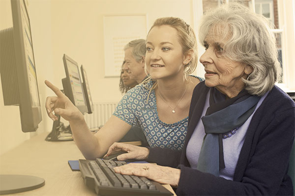 specialist assisting woman at library computer