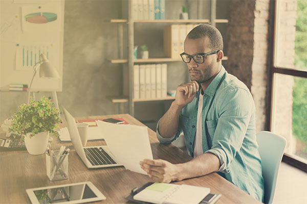 man at desk reading papers