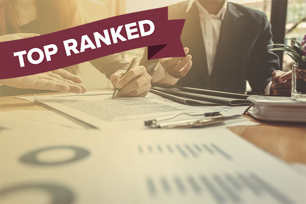 charts and files on conference table and "top ranked" banner