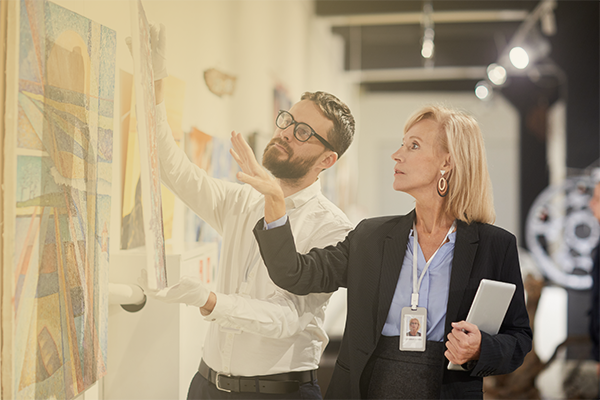 A female art administrator talking with a male curator in an art gallery setting