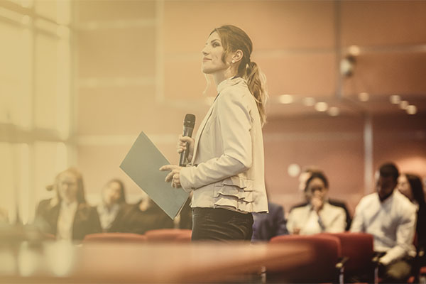 confident female educator presenting before audience