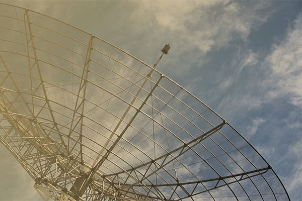 large satellite dish with blue sky in background